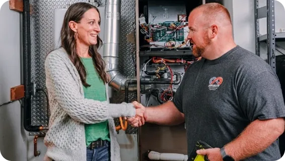 An Infinity technician shaking hands with a homeowner at their furnace