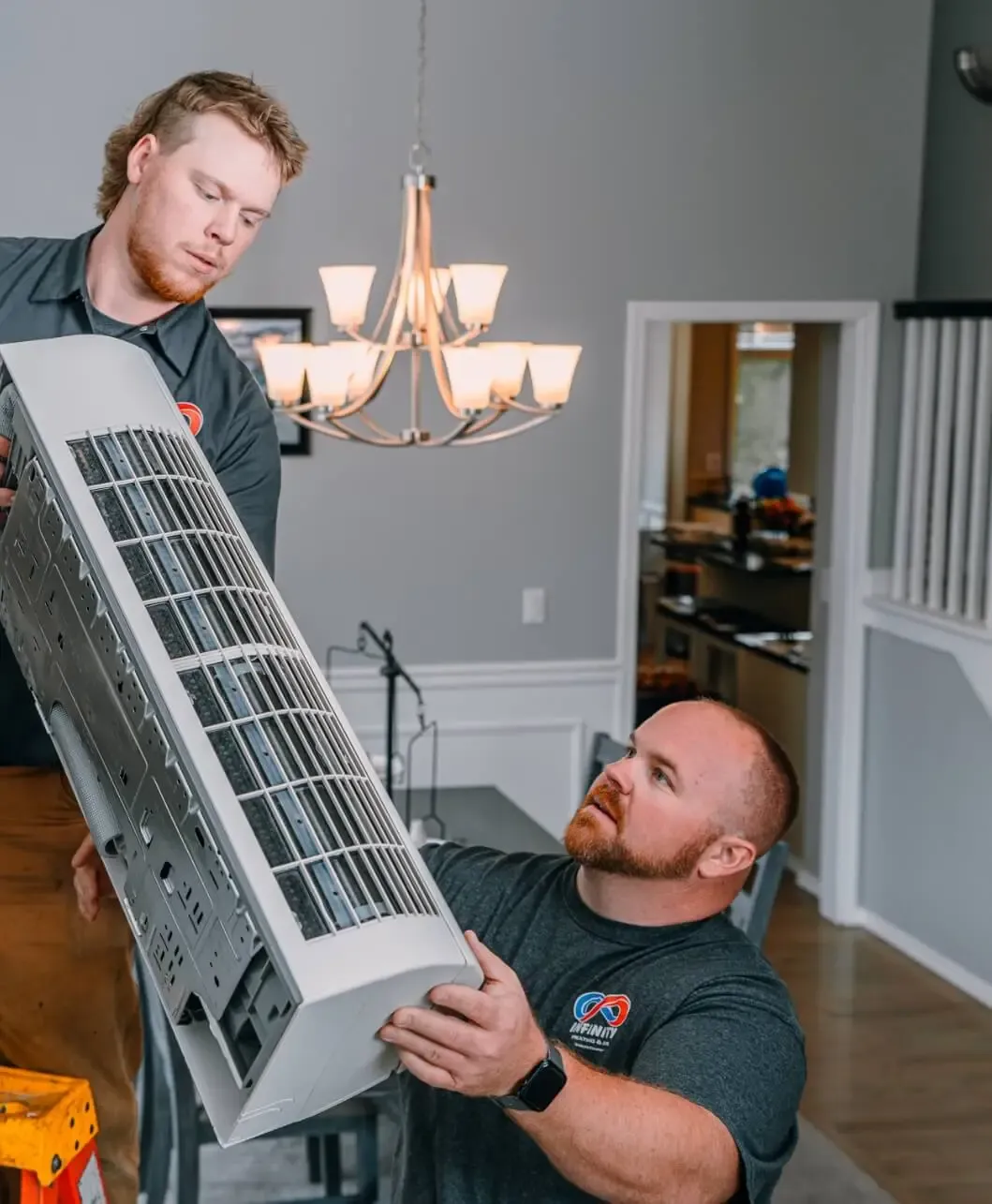 Infinity technicians installing a ductless mini-split indoor unit