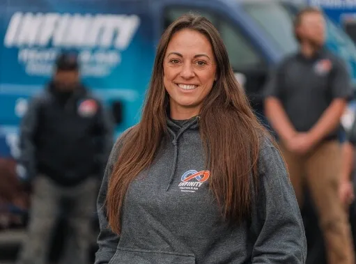An Infinity Heating & Air technician smiling on the job